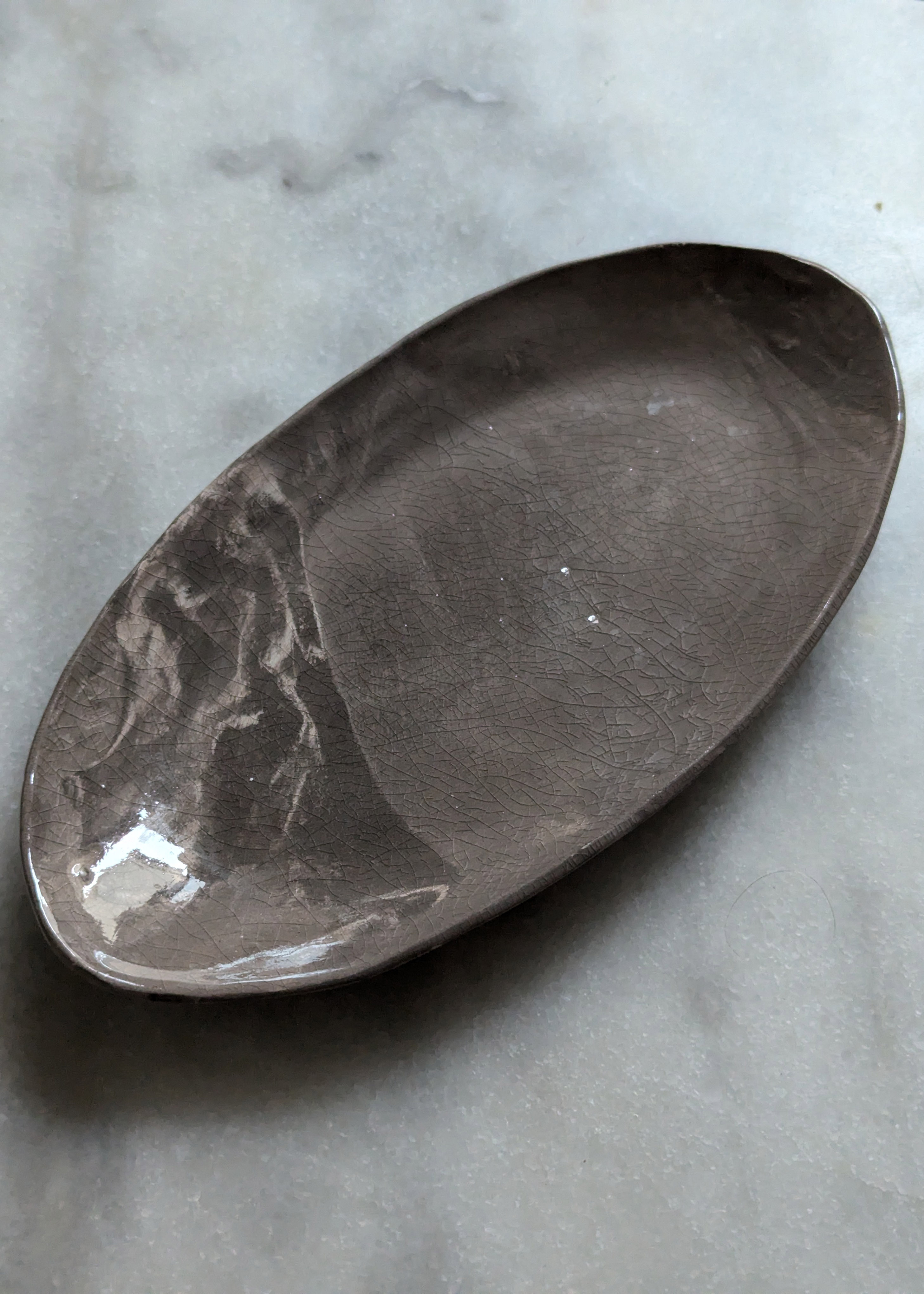 plat ovale en terre brune et blanche, en marbrure